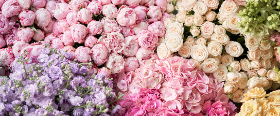 Many different colors on the stand or wooden table in the flower shop. Showcase. Background of mix of flowers. Beautiful flowers for catalog or online store. Floral shop and delivery concept. Top view