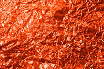 Fototapeta premium The texture of the red foil. Background for a holiday card or poster. A template for design.