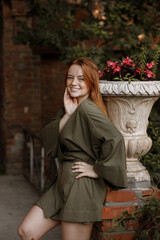 Naklejka premium Red-haired girl with freckles happy in town on a walk