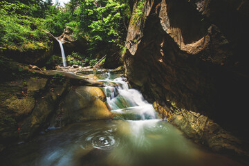 Deep forest river wild waterfall view.
