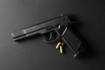 Pistol and traumatic bullets on black background. Self defense weapon