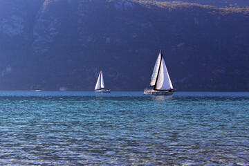 Fototapeta premium Beautiful seascape with mountains and sail boat on surface of calm water, travel and vacation mood