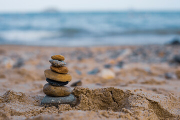 Pebbles are piled on a volcanic rock by the sea. Zen concept. Copy space