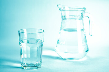 Glass with pure clear melt water on a blue background