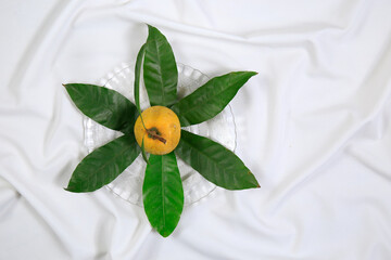Fresh tasty eggfruit decorated with leaves on a glass bowl