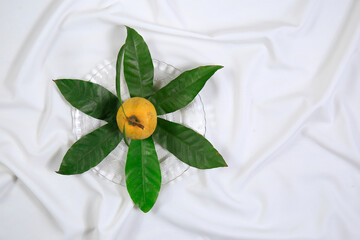Fresh tasty eggfruit decorated with leaves on a glass bowl