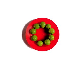 Green organic lemons with red plate on white background. healthy food concept