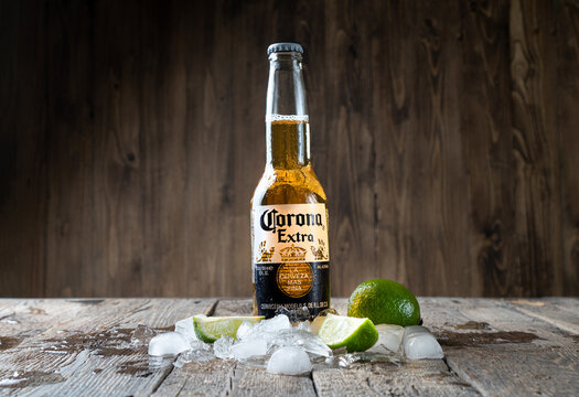 Kharkiv, Ukraine - 30 June, 2020: Illustrative editorial of Corona Beer bottle on the wooden background with ice and lime