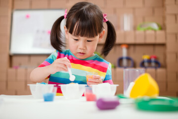 Obraz na płótnie Canvas toddler girl play science experiments for homeschooling