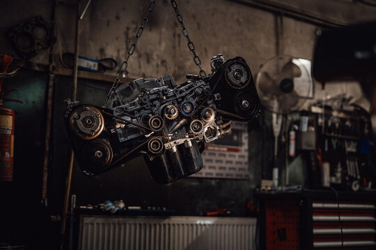 Closeup view of a suspended boxer engine in a dark garage or workshop