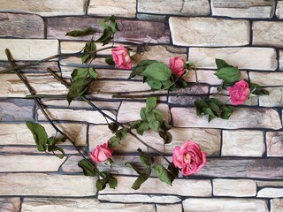 Dry faded pink roses on a background of stone tiles floor