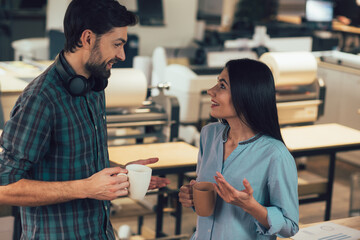 Smiling coworkers leading pleasant talk with tasty coffee