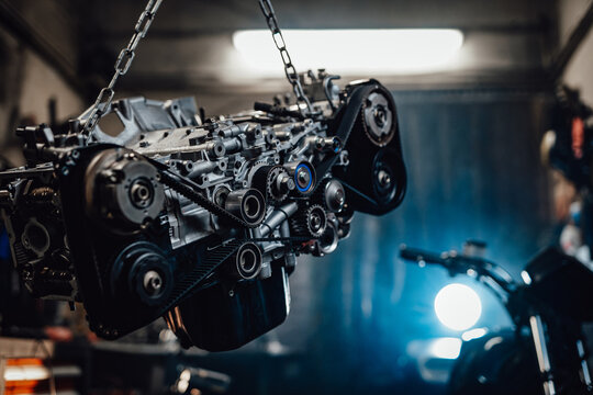 Closeup view of a suspended boxer engine in a dark garage or workshop