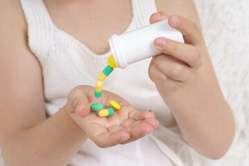 Sick teenage girl spills pills on her hand.
