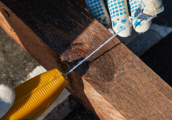 man holds a thread with chalk for marking a line on a wooden block