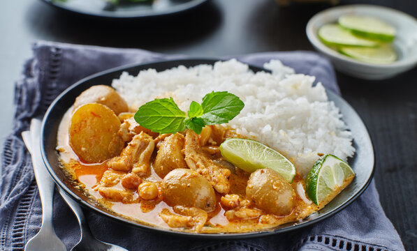 thai massaman curry on plate with jasmine rice and lime wedge