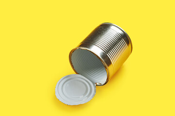 empty metal tin can isolated over yellow background. environment conversation concept. recycling concept.