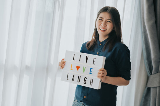 Happy Asian Woman Holding Live Love Laugh Sign