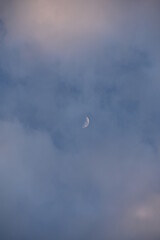 Rosa beleuchtete Wolken am Himmel am Abend leuchten mit Mond (Halbmond)