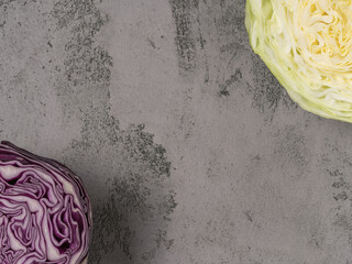 Obraz premium Organic white cabbage and red cabbage in cross section. The gray background.