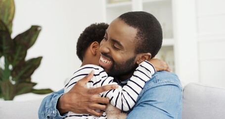 Portrait of African American dad hugging his cute little daughter. Happy Father's day.