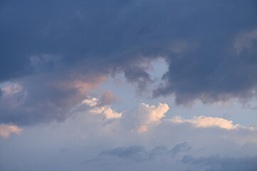 Naklejka na ściany i meble Beleuchtete Wolken am Himmel am Abend leuchten in hellen Farben