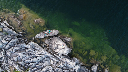 Drone shot of fishers waiting with patience, coastal fishing scenery, a coastal fishing perspective from a drone, people fishing at coast 
