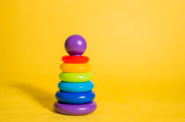 Children's pyramid toy on a yellow isolated background with space for text