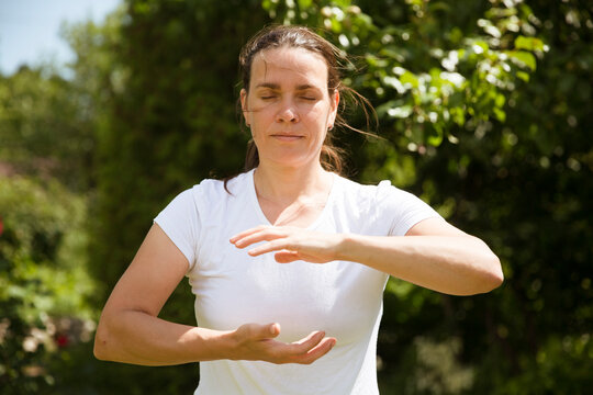 Woman practice Tai Chi Chuan in a park.  Chinese management skill Qi's energy. solo outdoor activities. Social Distancing 