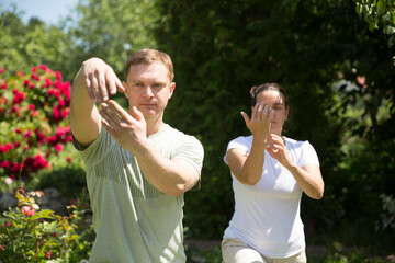 Couple practice Tai Chi Chuan in a park.  Chinese management skill Qi's energy. solo outdoor activities. Social Distancing 