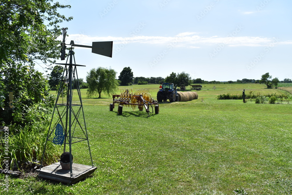 Sticker windmill, hay rake, hay bales, and tractor