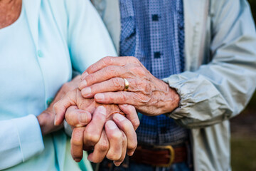 elderly married couple holding hands 