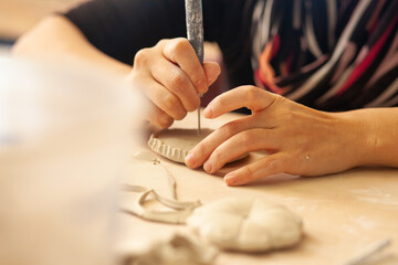 female artist working with clay in their studio