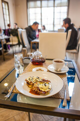 eggs benedict breakfast at a table in a restaurant during brunch hours