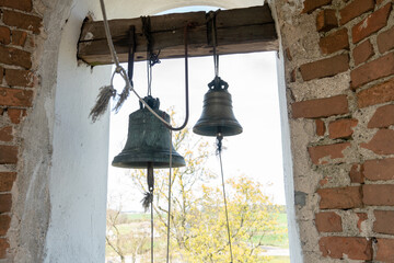 Fototapeta premium inside the bell tower. View of the large iron bells. Old bell tower of red brick.