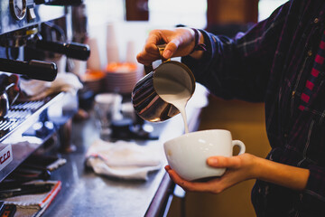 pouring coffee into a cup of coffee at a cafe