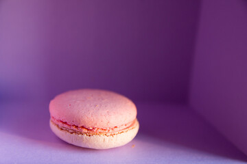 One small macaroon cake in the violet box. Blurred object