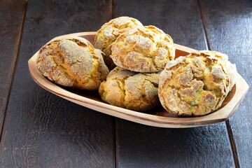 small homemade bread, biscuit called Broa or broinha, bread made from corn, on a rustic wooden background.