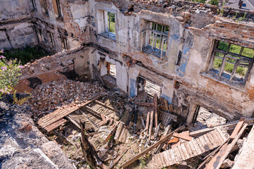 Abandoned ruined house, empty windows, charred walls, trash on the floor.