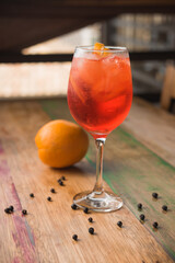 Classic Italian Aperol Spritz cocktail, with lemon in the background