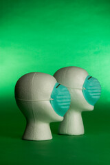 two white heads with protective blue face masks