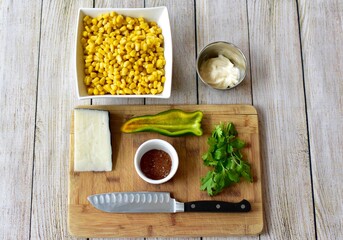 Measured and whole ingredients ready for making simple and tasty fresh street corn salad at home or in a cooking class