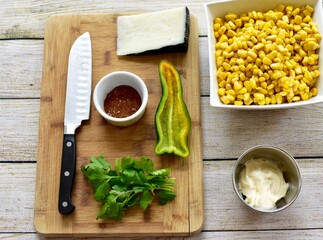 Measured and whole ingredients ready for making simple and tasty fresh street corn salad at home or in a cooking class