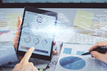 Double exposure of man's hand holding and using a digital device and brain hologram drawing. Data concept.