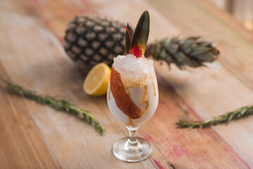 pina colada Cocktail drink, with pineapple, lemon, rosemary in the background,