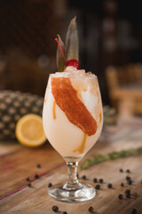 pina colada Cocktail drink, with pineapple, lemon, rosemary in the background,