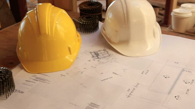Construction site showing plans and hardhats.