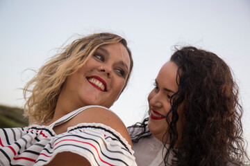 Fototapeta premium happy girlfriends look at each other and smile