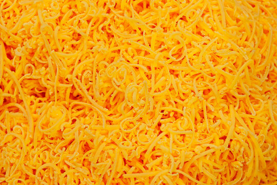 grated red cheddar cheese in close up