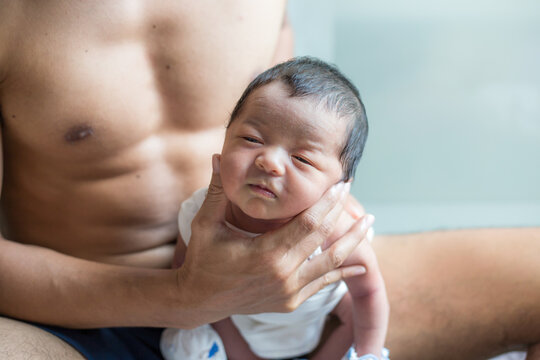 Beautiful young Asian father hold newborn baby boy with hand to help baby belch or Making burp after feeding
